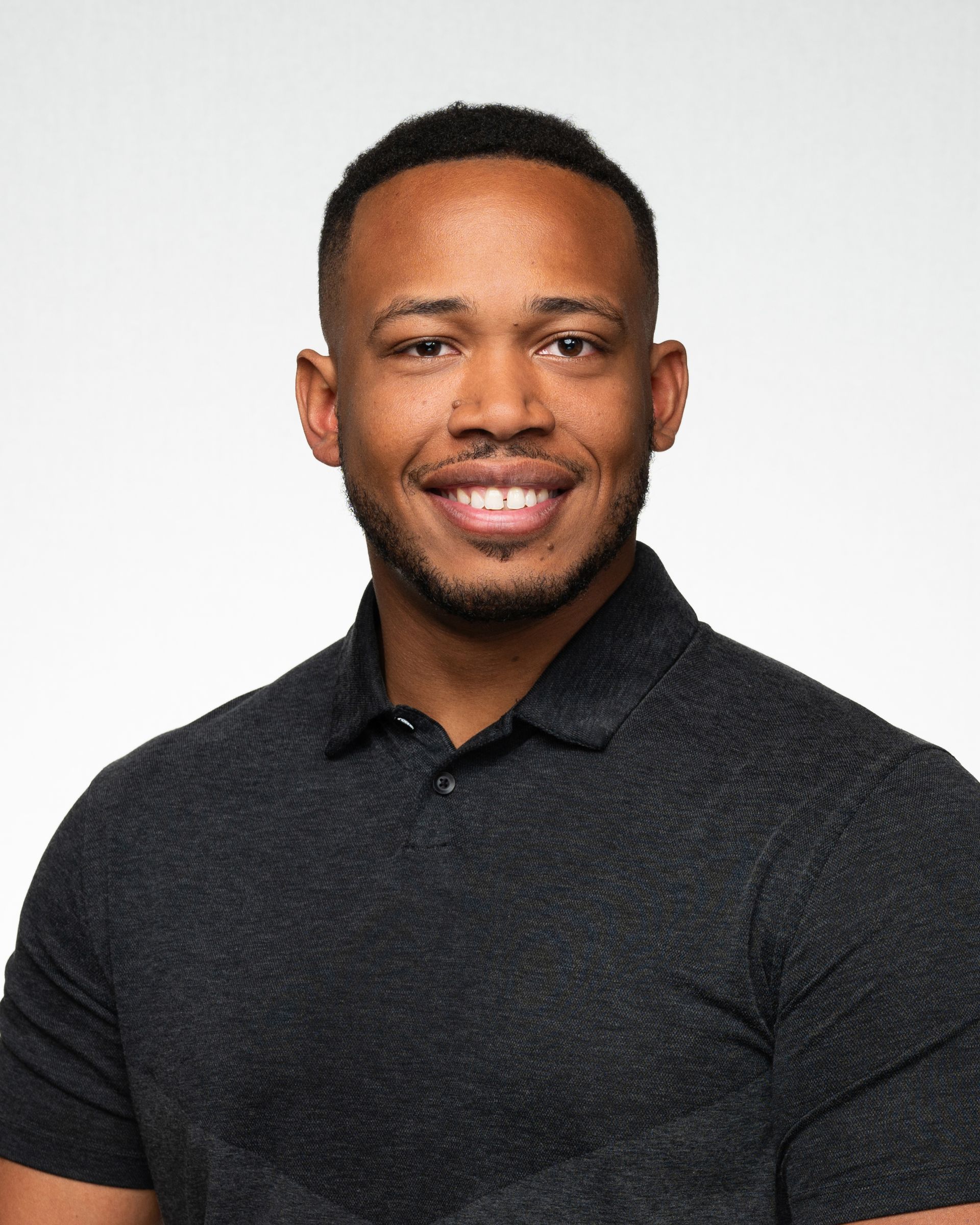 a man wearing glasses and a hat is standing in front of a white background .