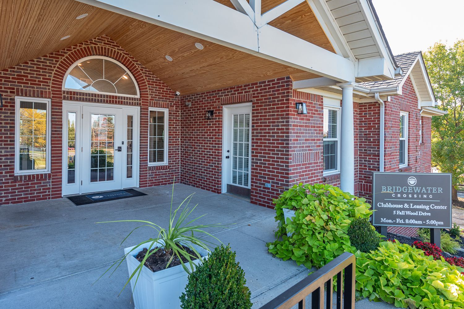 Brick building with white trim, arched doorway, and a sign for Blue Water Condominiums.