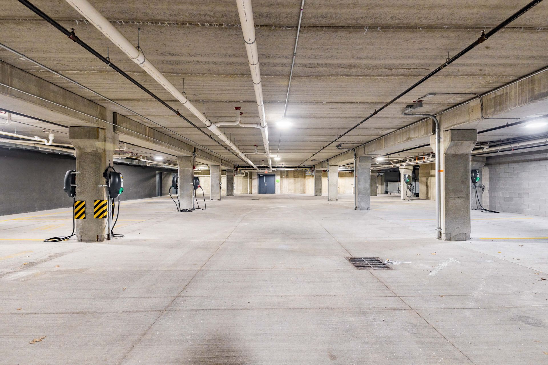 Empty underground parking garage with concrete pillars and bright overhead lights