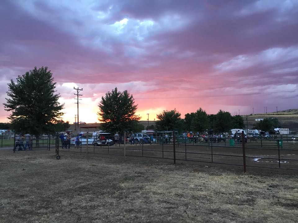 A fenced in area with a sunset in the background