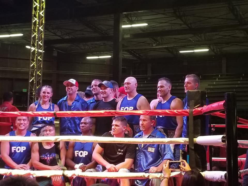 Coach Jerrod Hardy in boxing ring with FOP boxers following charity event
