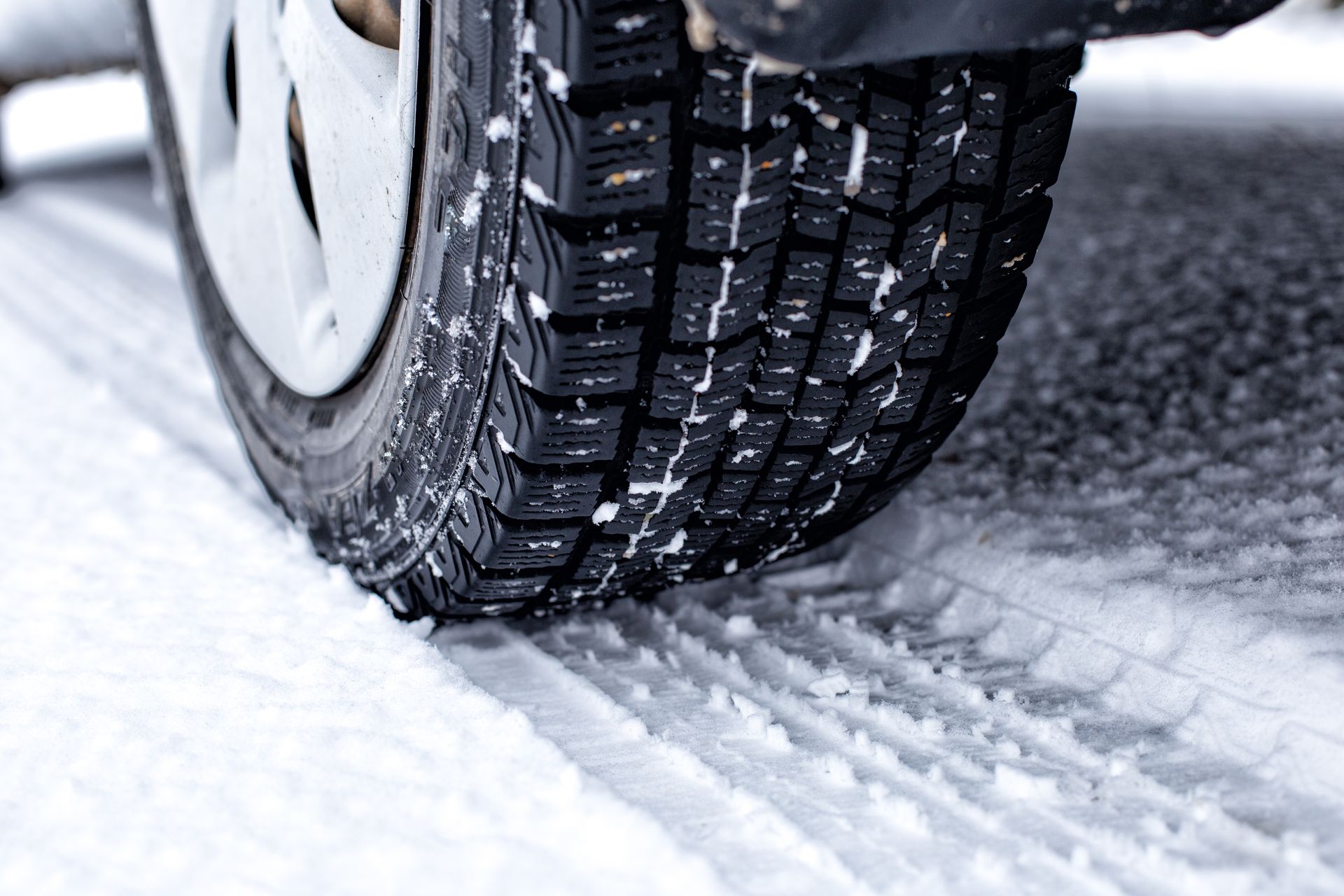 A close up of a tire on a snowy road.