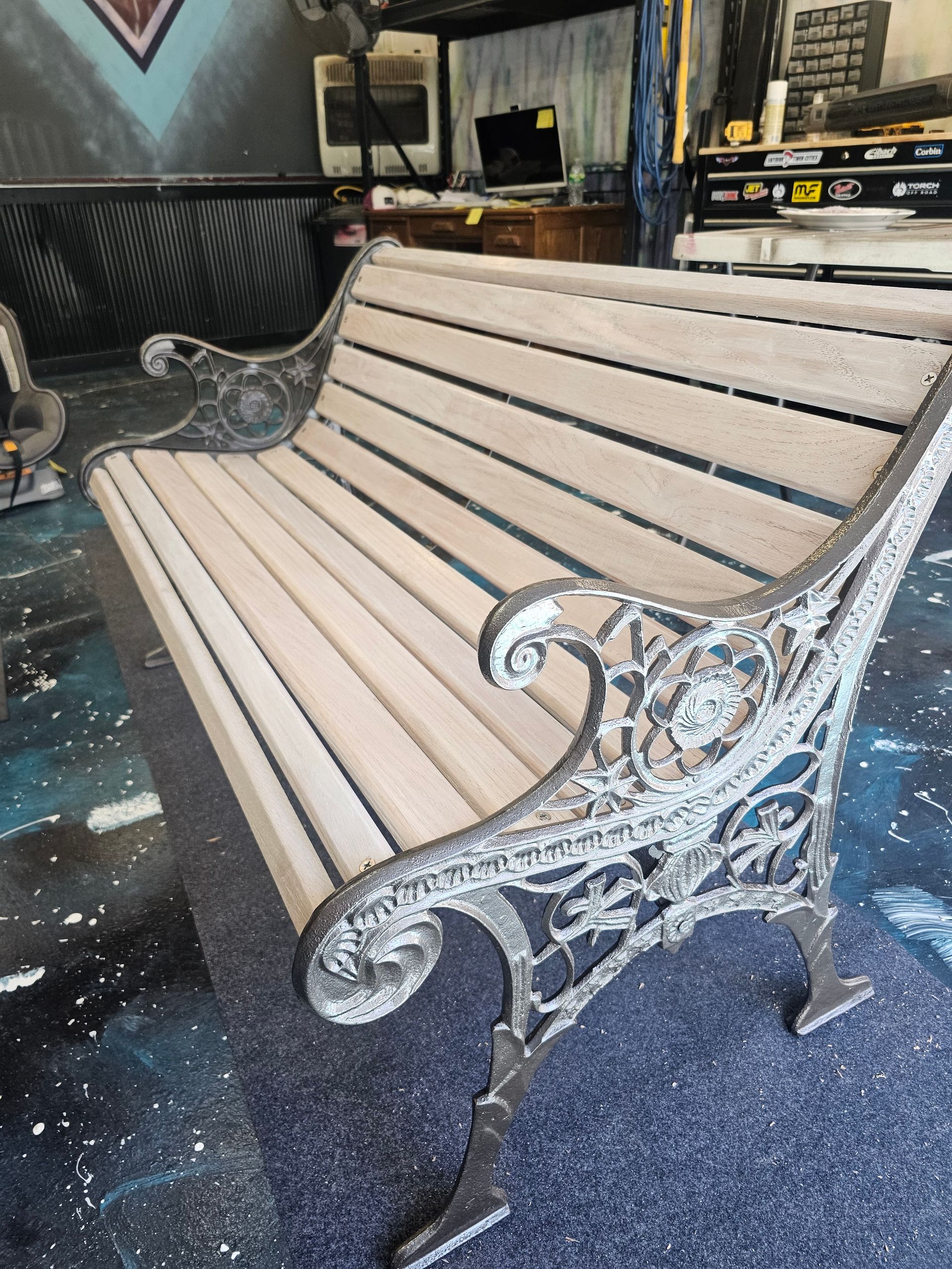 A park bench is sitting on a carpeted floor in a room.