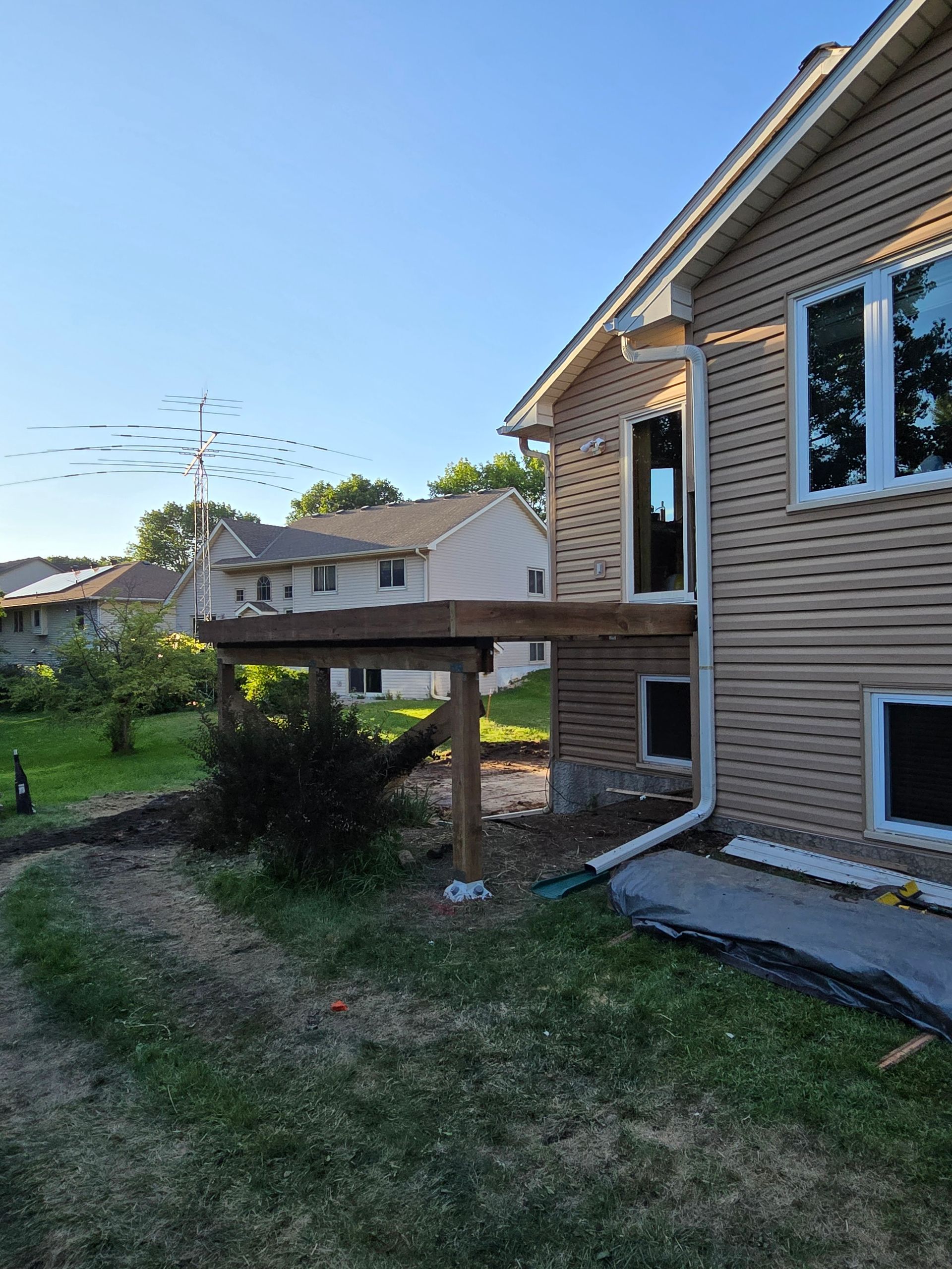 A house with a wooden deck in front of it.