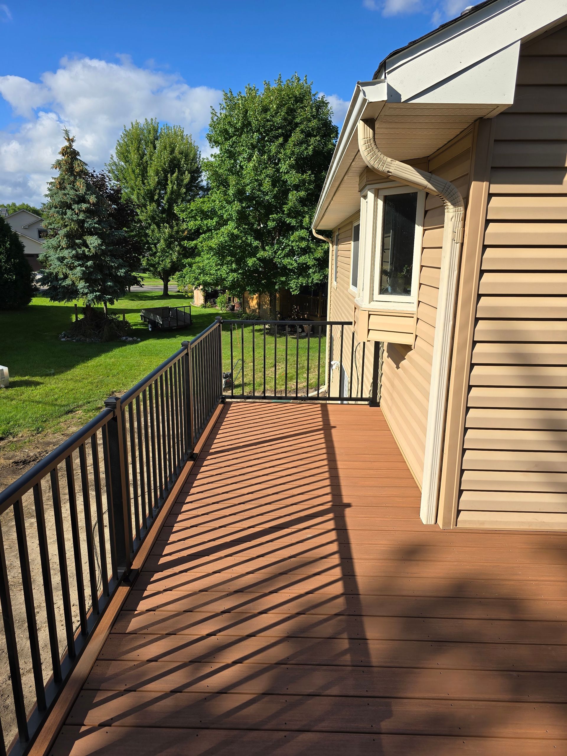 A house with a wooden deck and a metal railing