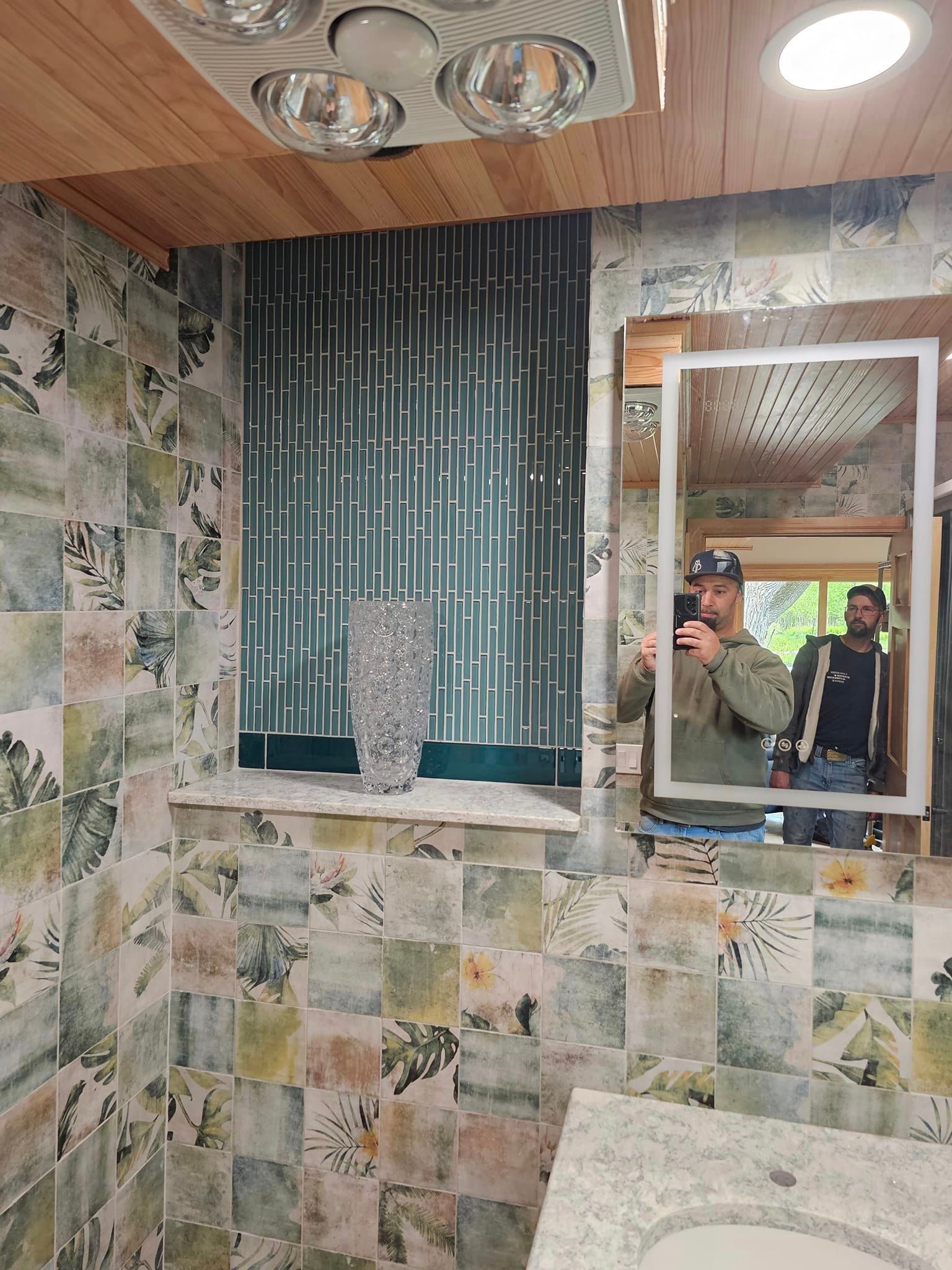 A man is taking a picture of himself in a bathroom mirror.