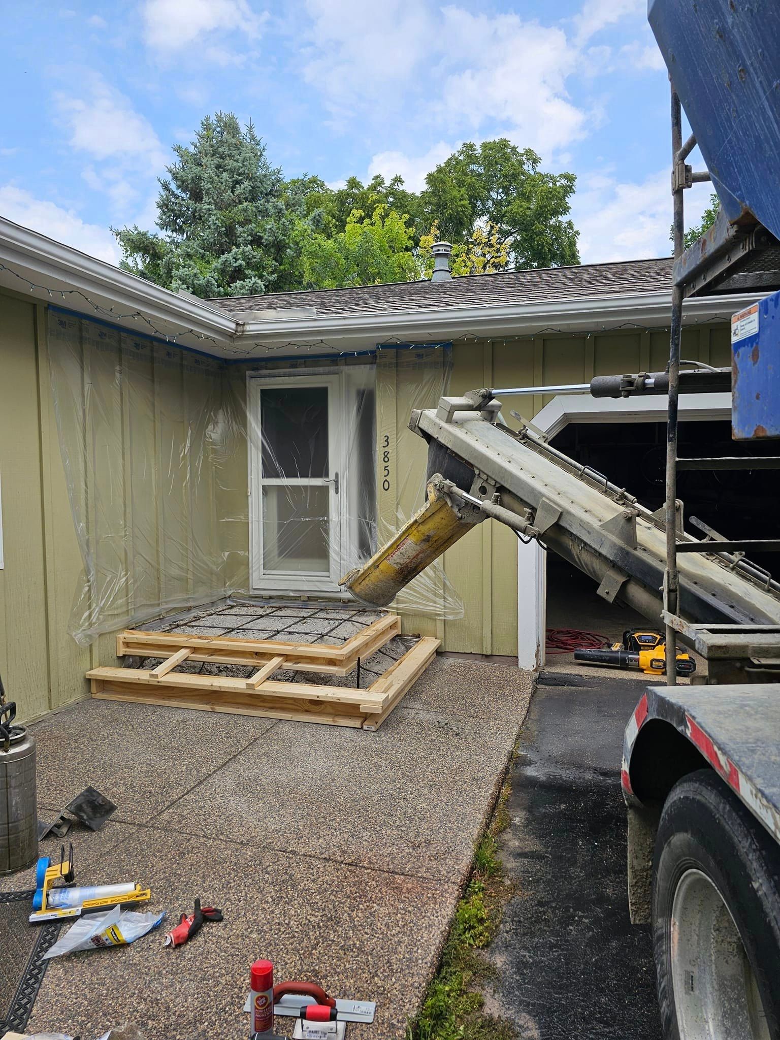 A concrete truck is pouring concrete into a house.
