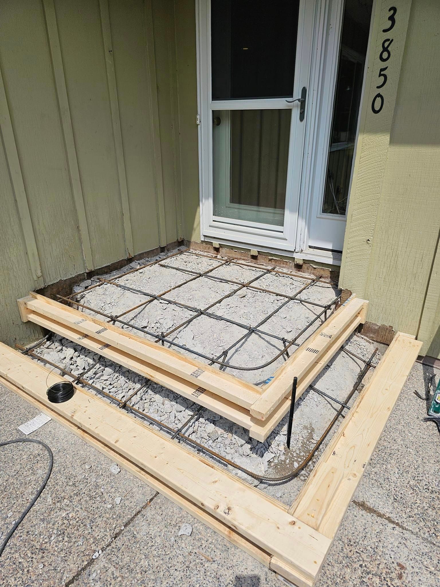 A concrete staircase is being built in front of a house.