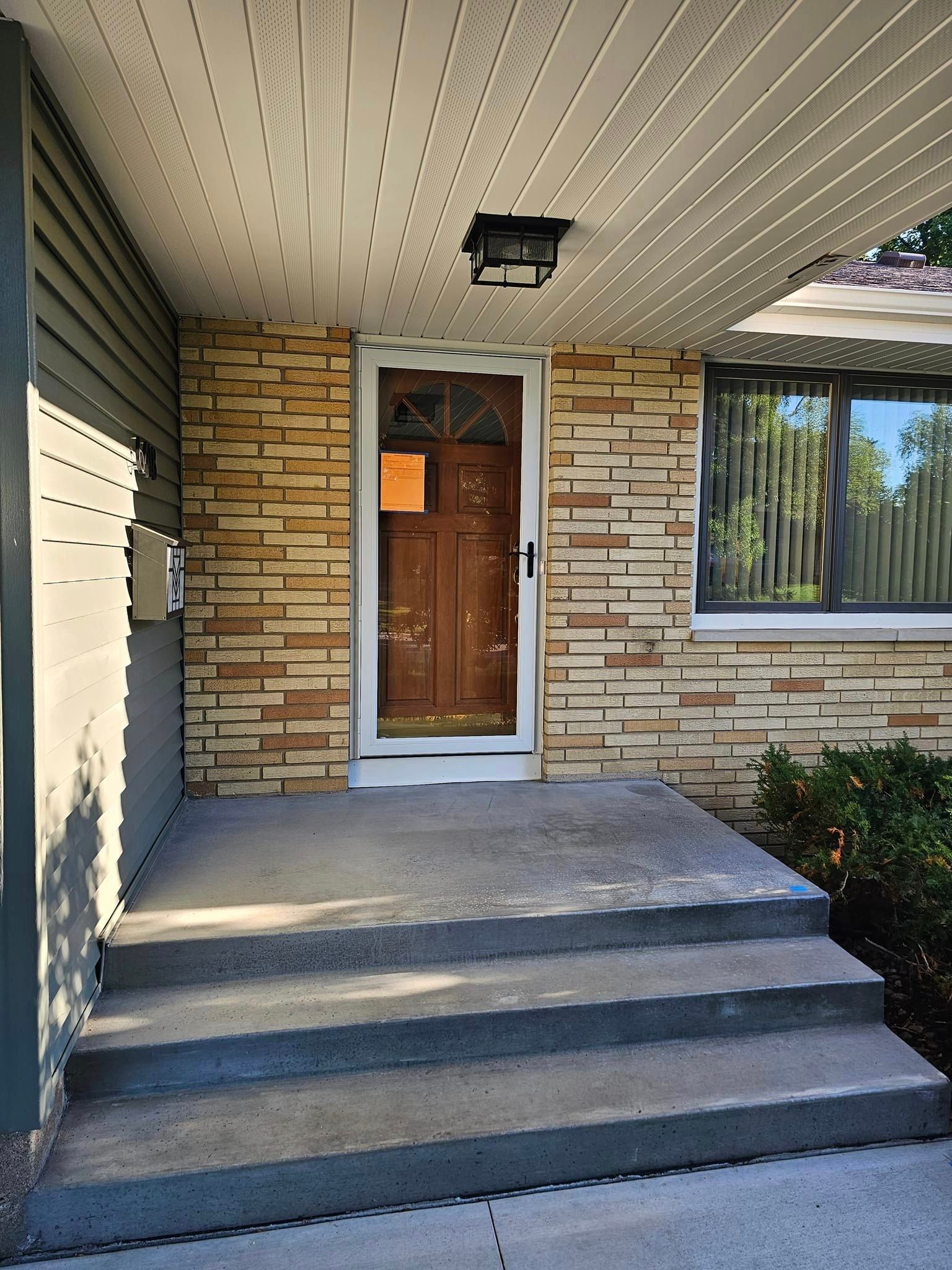 A brick house with a front porch and stairs