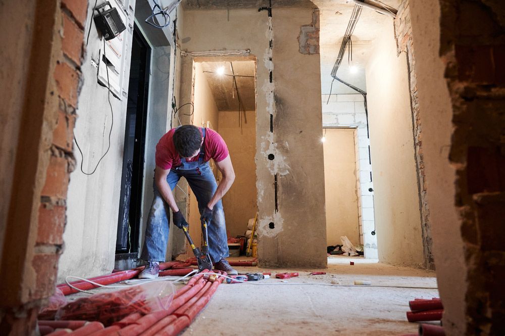 A Plumber is Working on the Red Pipes On The Floor of a Building — Cuttle Plumbing in Armidale, NSW