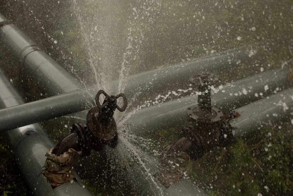 A Close Up of a Water Pipe With Water Spraying Out of It — Cuttle Plumbing in Armidale, NSW