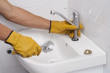 A Plumber is Working on a Pipe With a Wrench and a Pressure Gauge — Cuttle Plumbing in Armidale, NSW