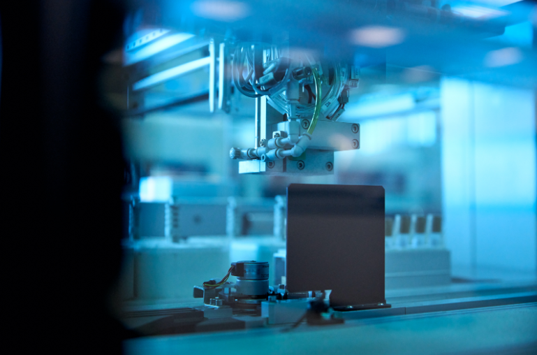 A robotic arm is holding a box in a factory.