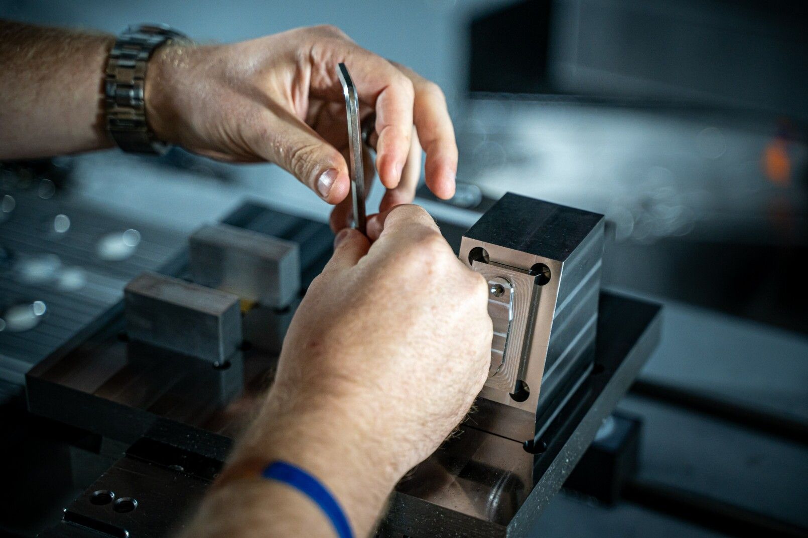 A man is working on a piece of metal in a factory.