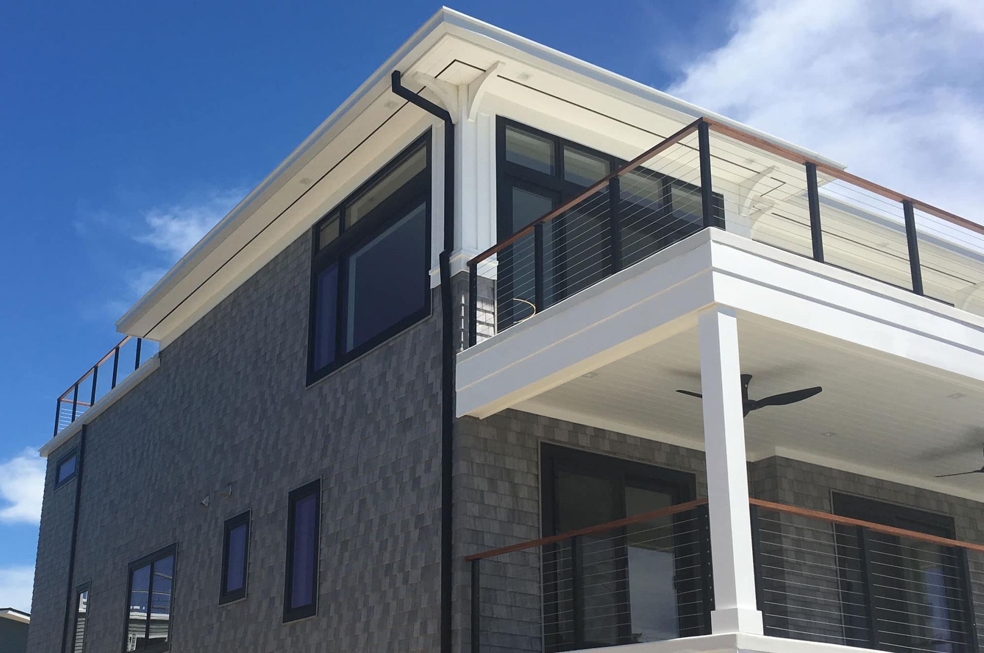 A large house with a balcony and a blue sky in the background