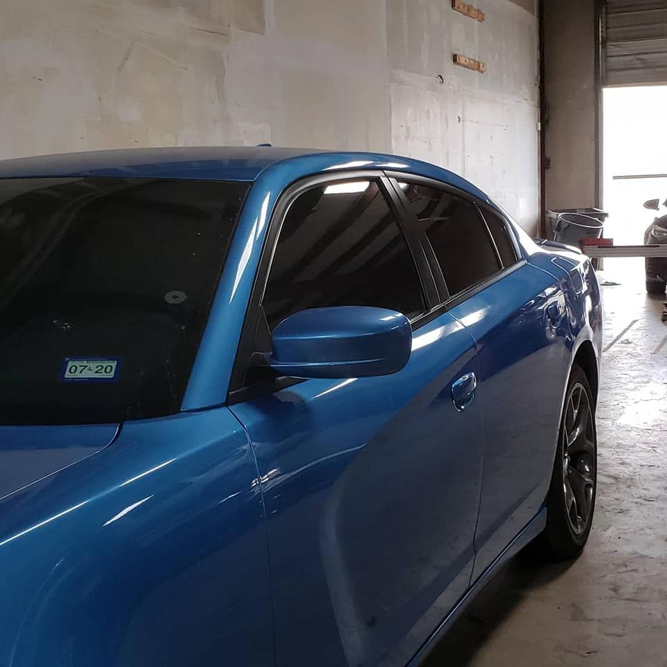 Woman with brown hair laughs, wearing a green shirt, against a white background.