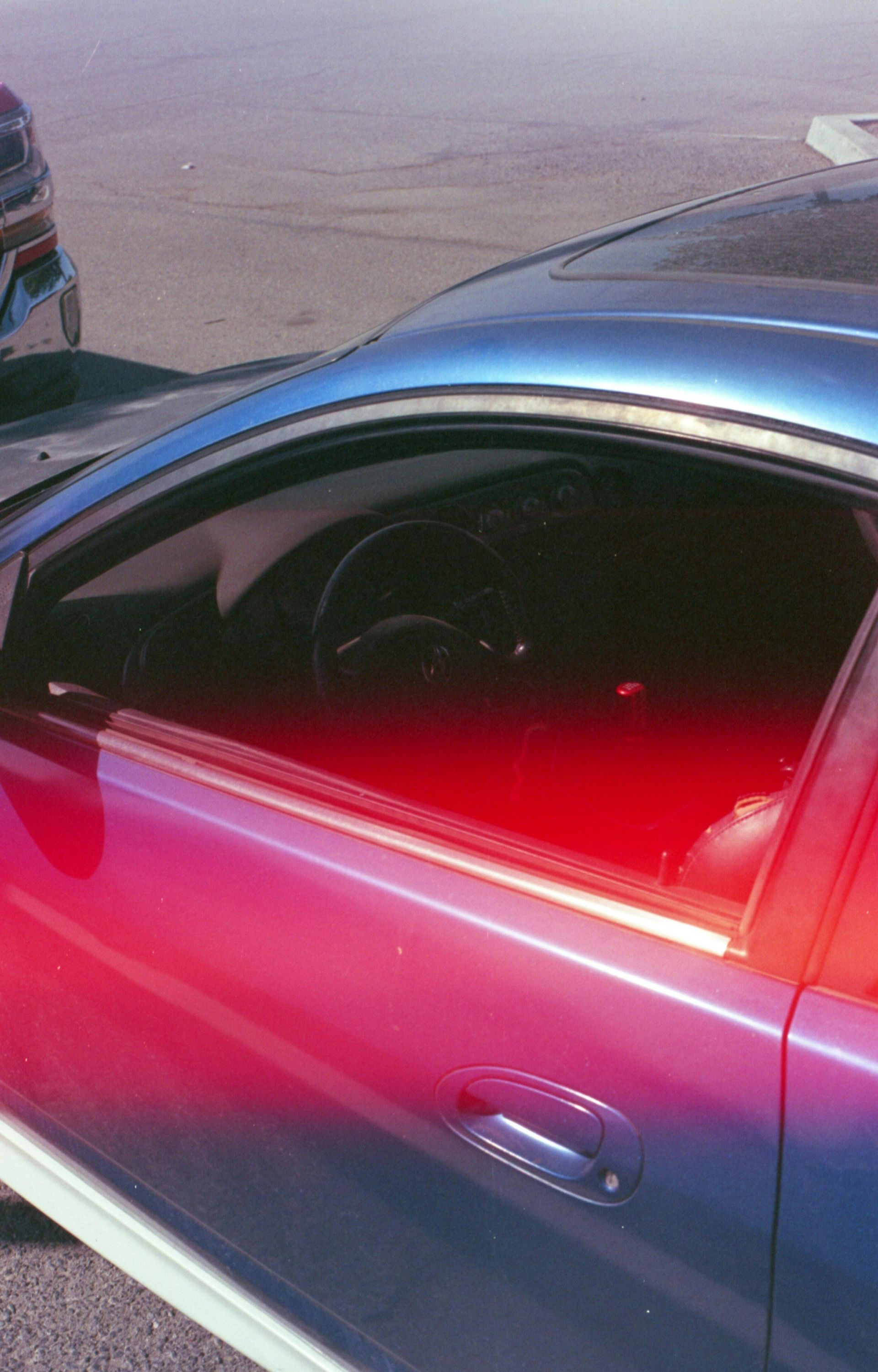 Blue car door, red and blue lighting effect, interior visible.