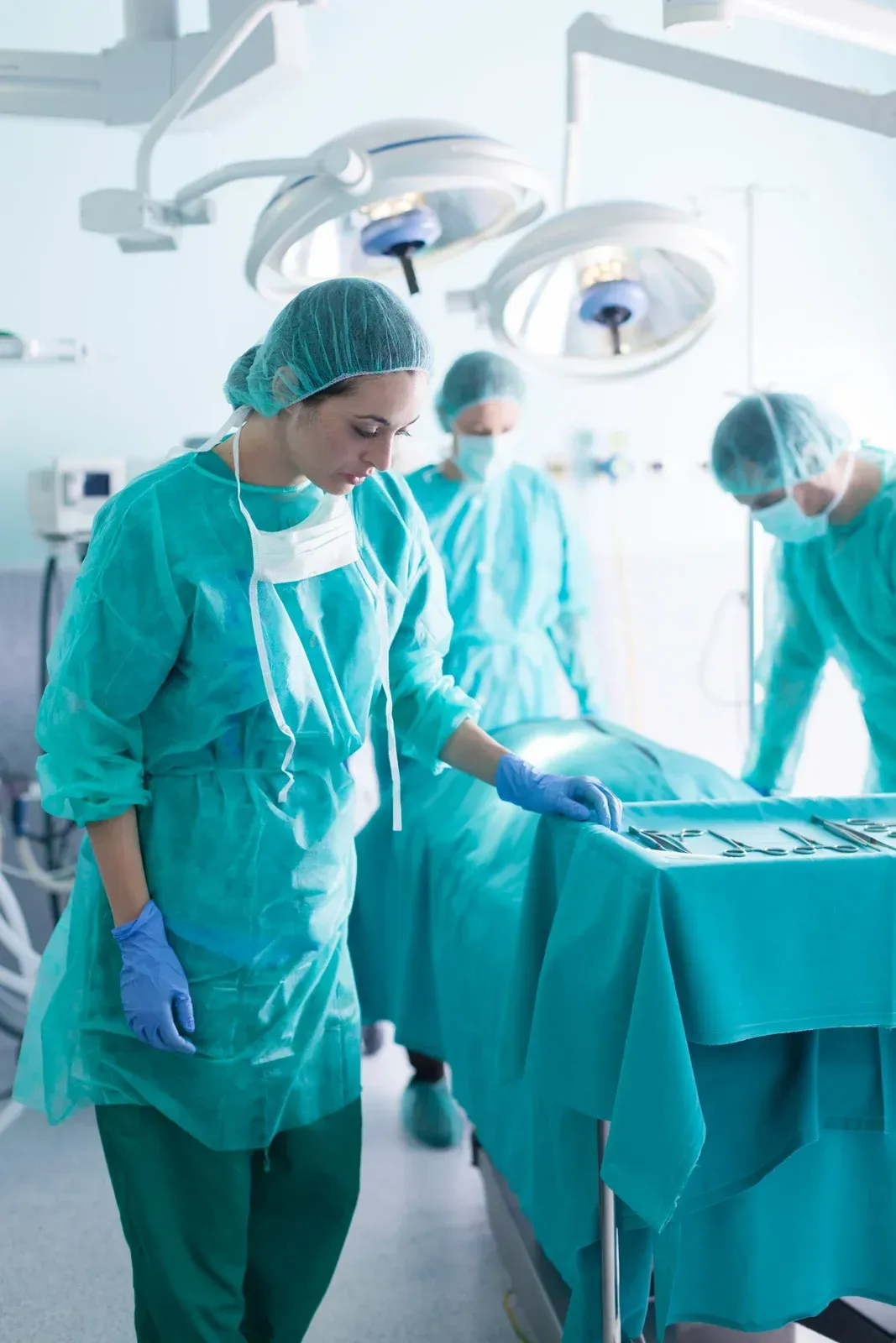 Scientist pours red liquid into a beaker, surrounded by colorful lab equipment.
