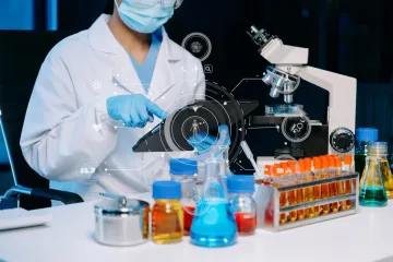Lab worker in white coat with microscope, test tubes, and digital overlay, studying samples.