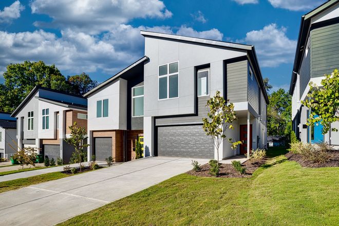 a white and gray house with a yellow door and a garage .