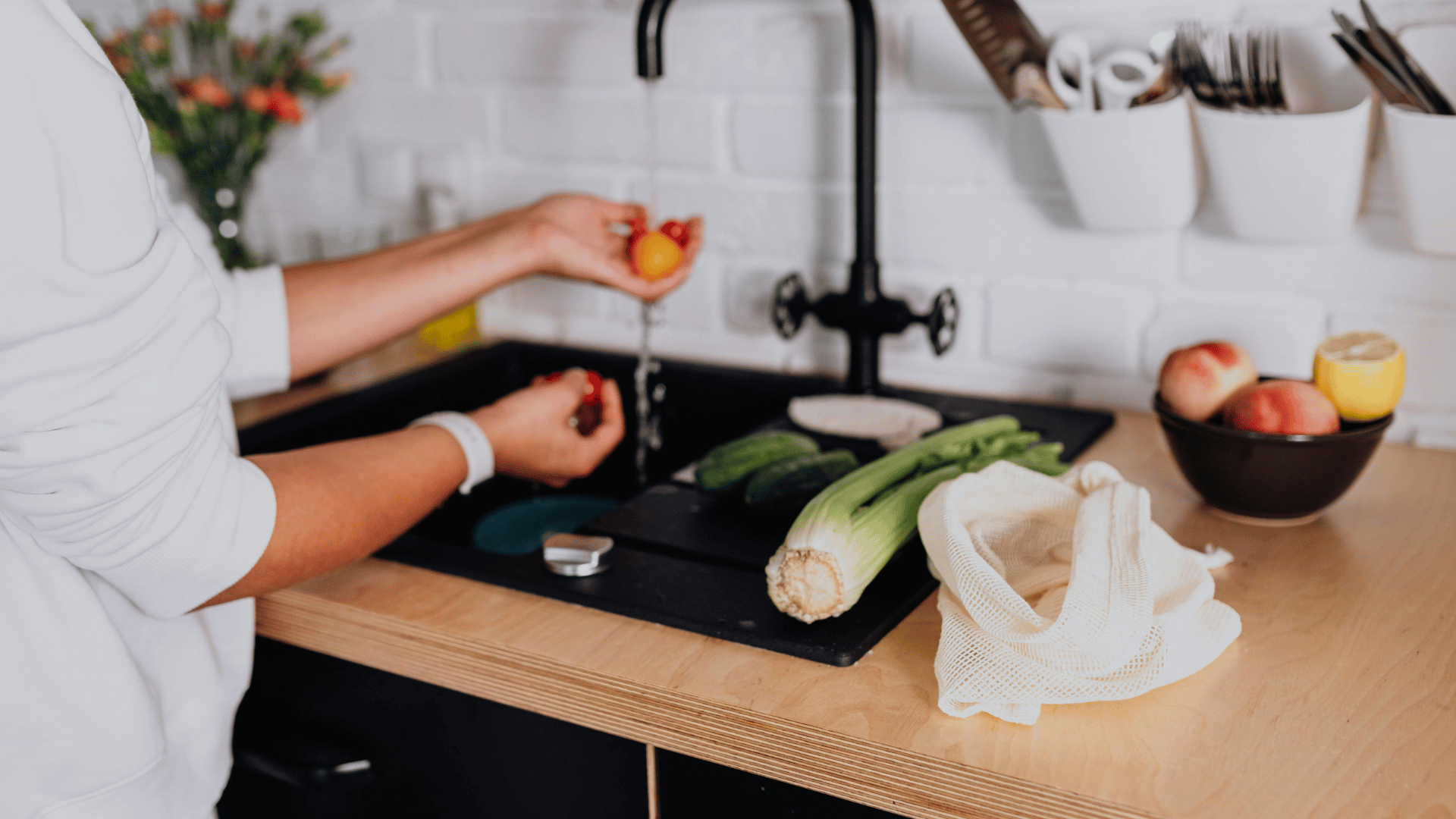 Man in gloves and safety glasses repairs water heater in a room.