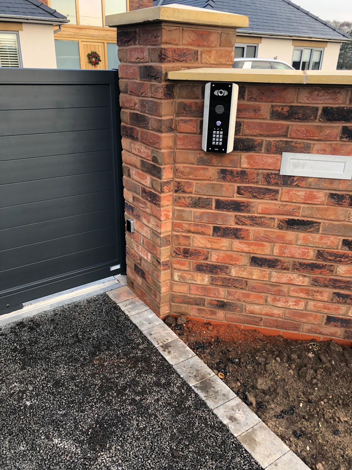 aluminium gate with an intercom on the wall