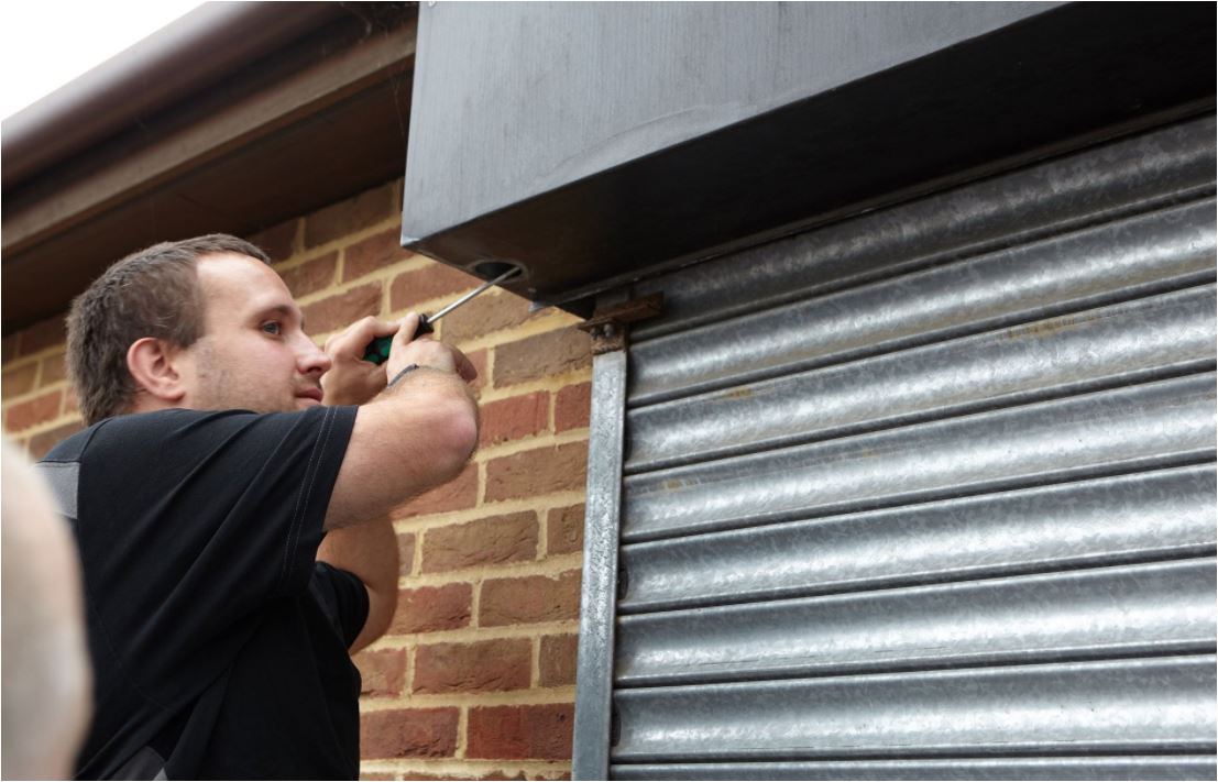 A man repairing a roller shutter door