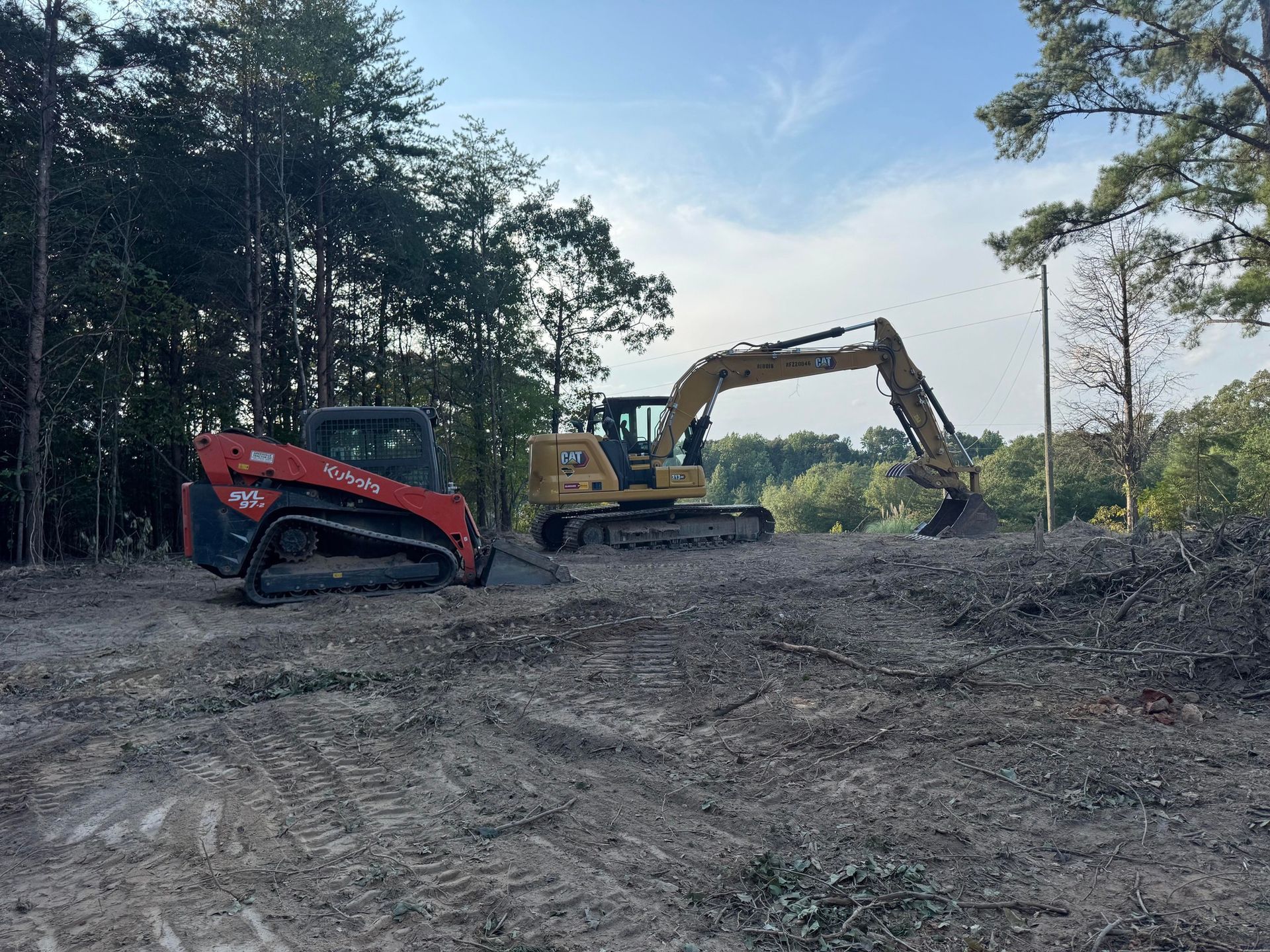 Red skid steer loading dirt on a sunny day.