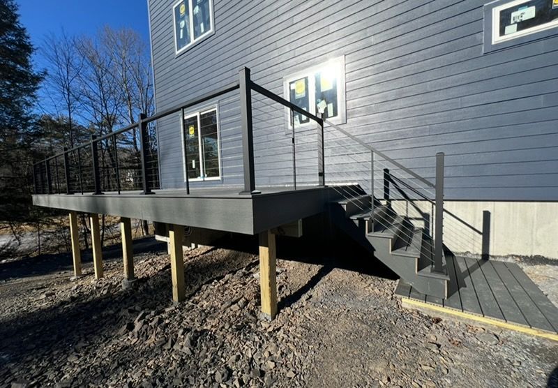 A house with a deck and stairs on the side of it.