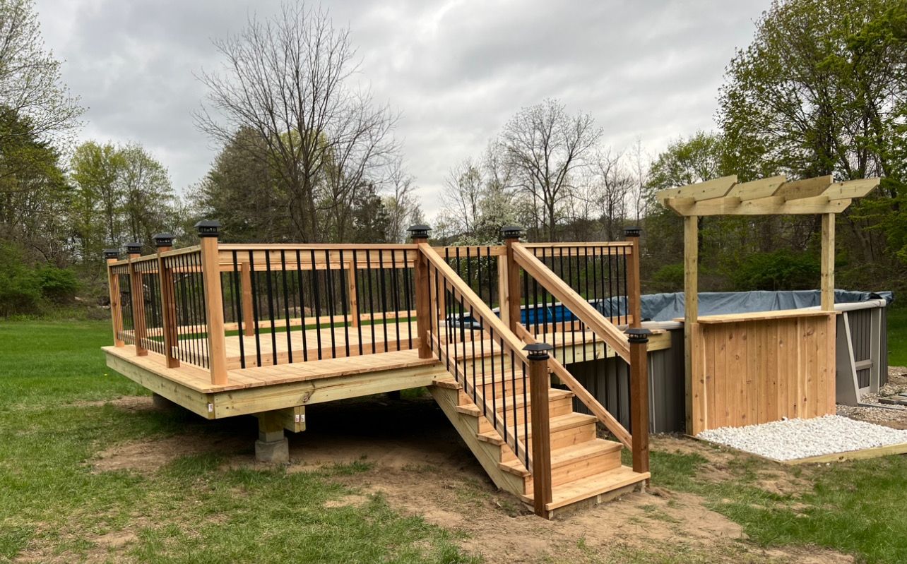 A wooden deck with stairs and a pergola next to a pool.