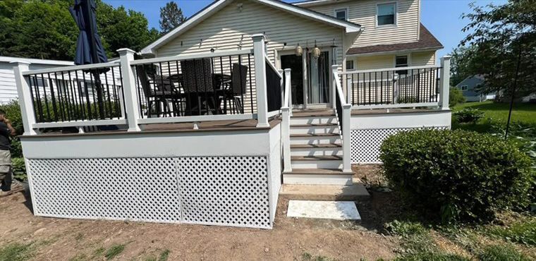 A house with a deck and stairs in front of it.