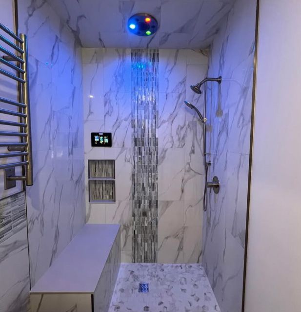 A bathroom with a shower with a blue light on the ceiling