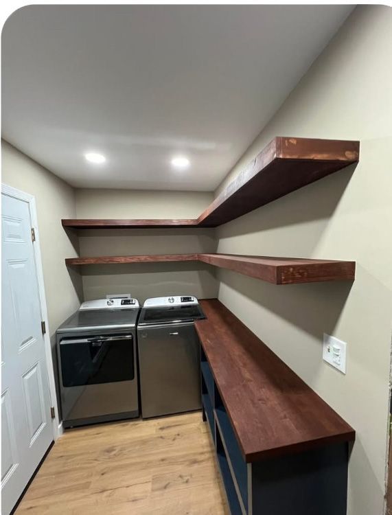 A laundry room with wooden shelves and a washer and dryer