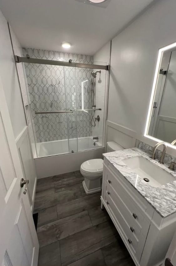 A bathroom with a sink , toilet , bathtub and mirror.