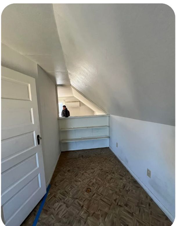 An empty room with a wooden floor and white walls.