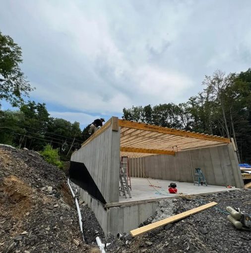 A man is working on the roof of a garage under construction.
