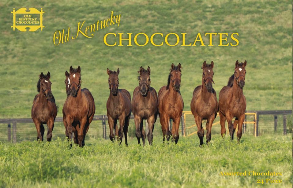 A silver bowl and serving platter filled with an assortment of colorful, decorated chocolates.