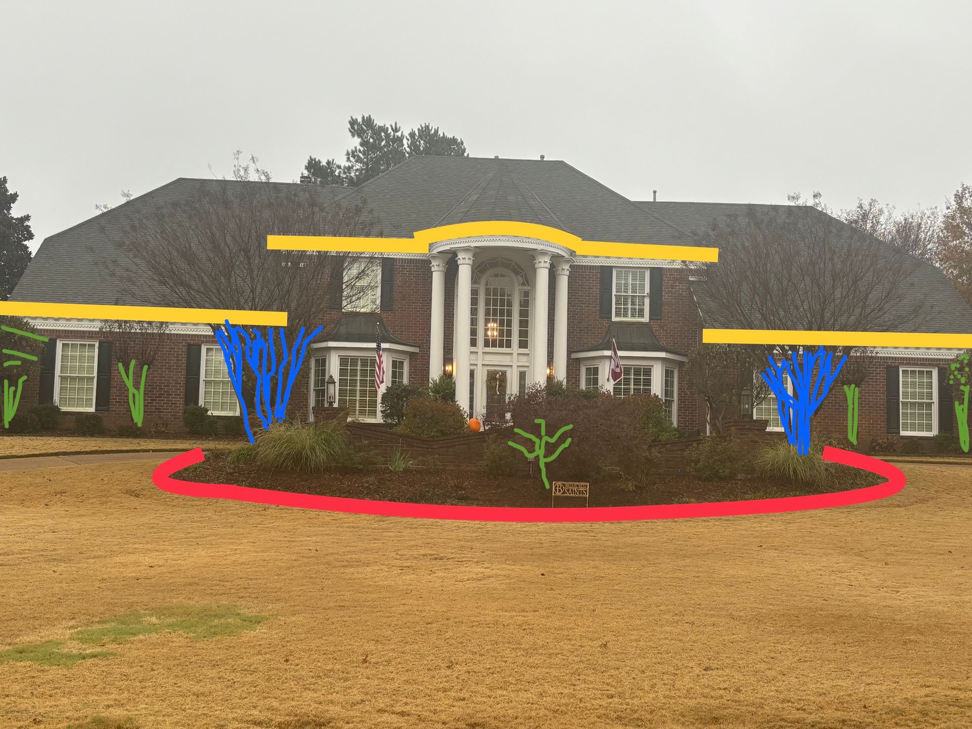 A large brick house with a curved flowerbed in front, trees and bushes of varying shapes, and a grassy lawn.