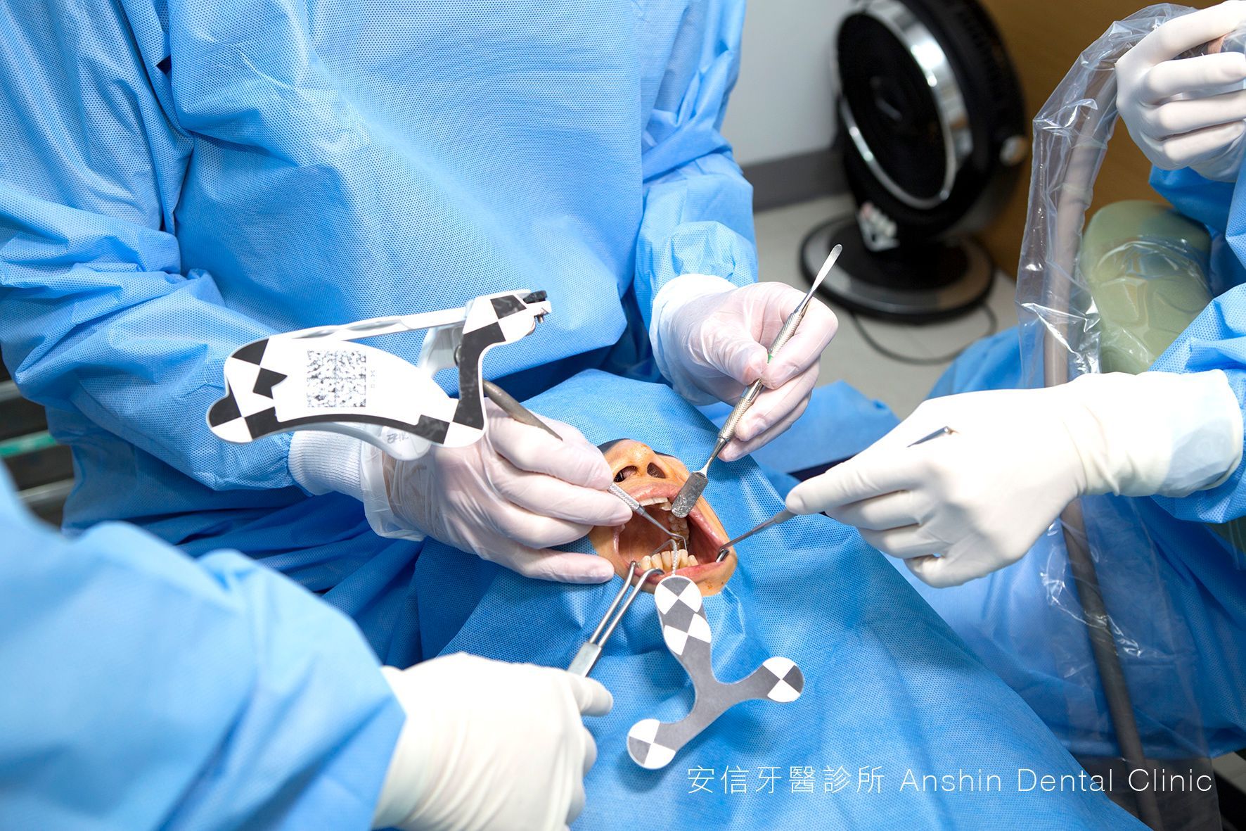 A group of dentists are working on a patient 's teeth.