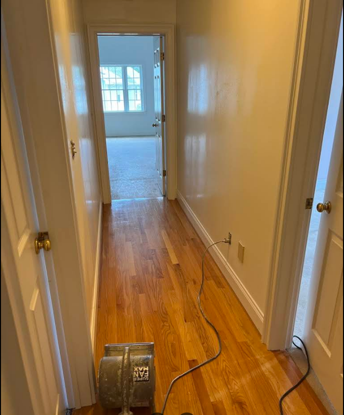 A vacuum cleaner is sitting in a hallway next to a door.