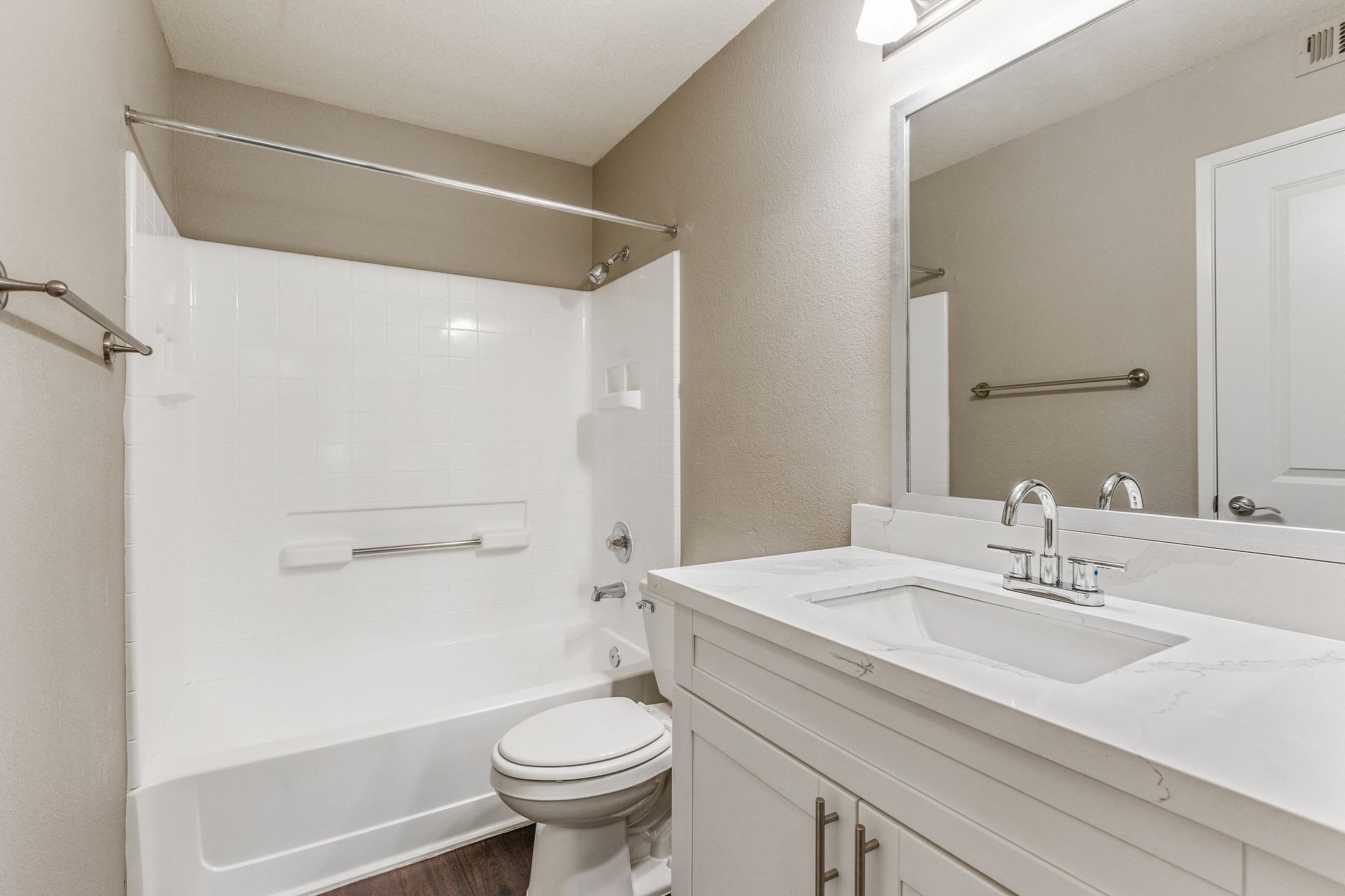 Bathroom with white tub/shower, toilet, and vanity