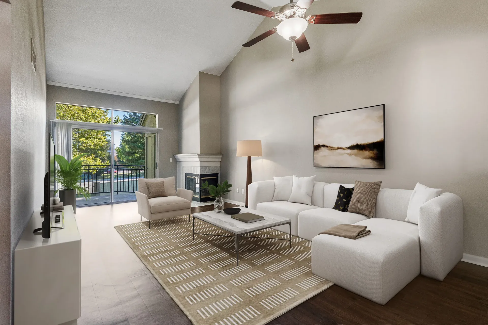 Living room in an apartment with a white sectional, coffee table, fireplace, and balcony door.