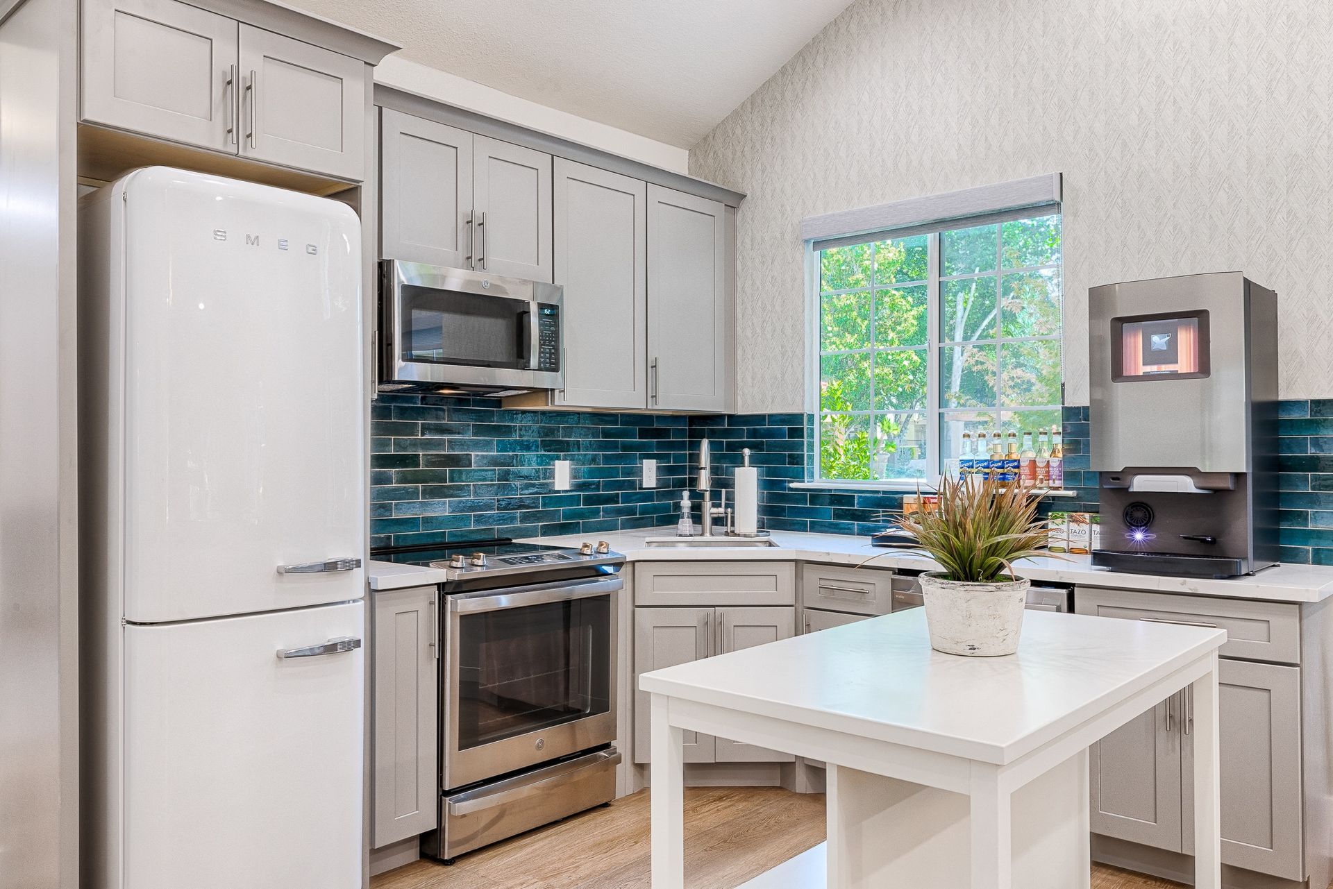 Modern gray-cabinet kitchen with stainless appliances and a white island.