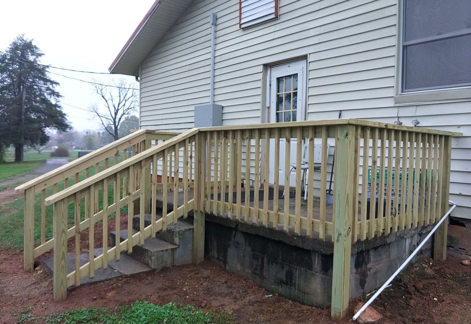 A man wearing a hard hat and gloves is using a device to measure the thickness of a wall.