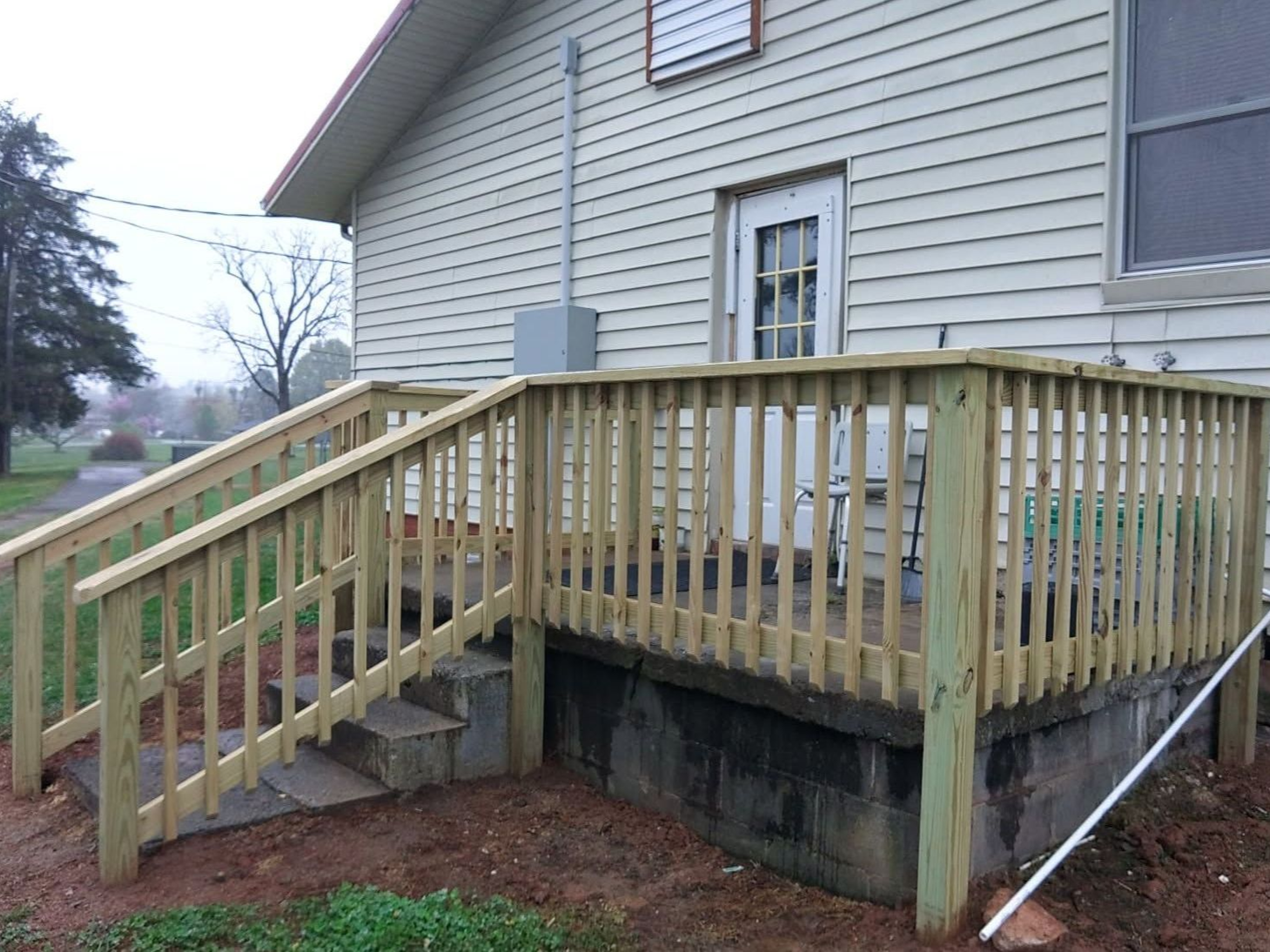 A man wearing a hard hat and gloves is using a device to measure the thickness of a wall.