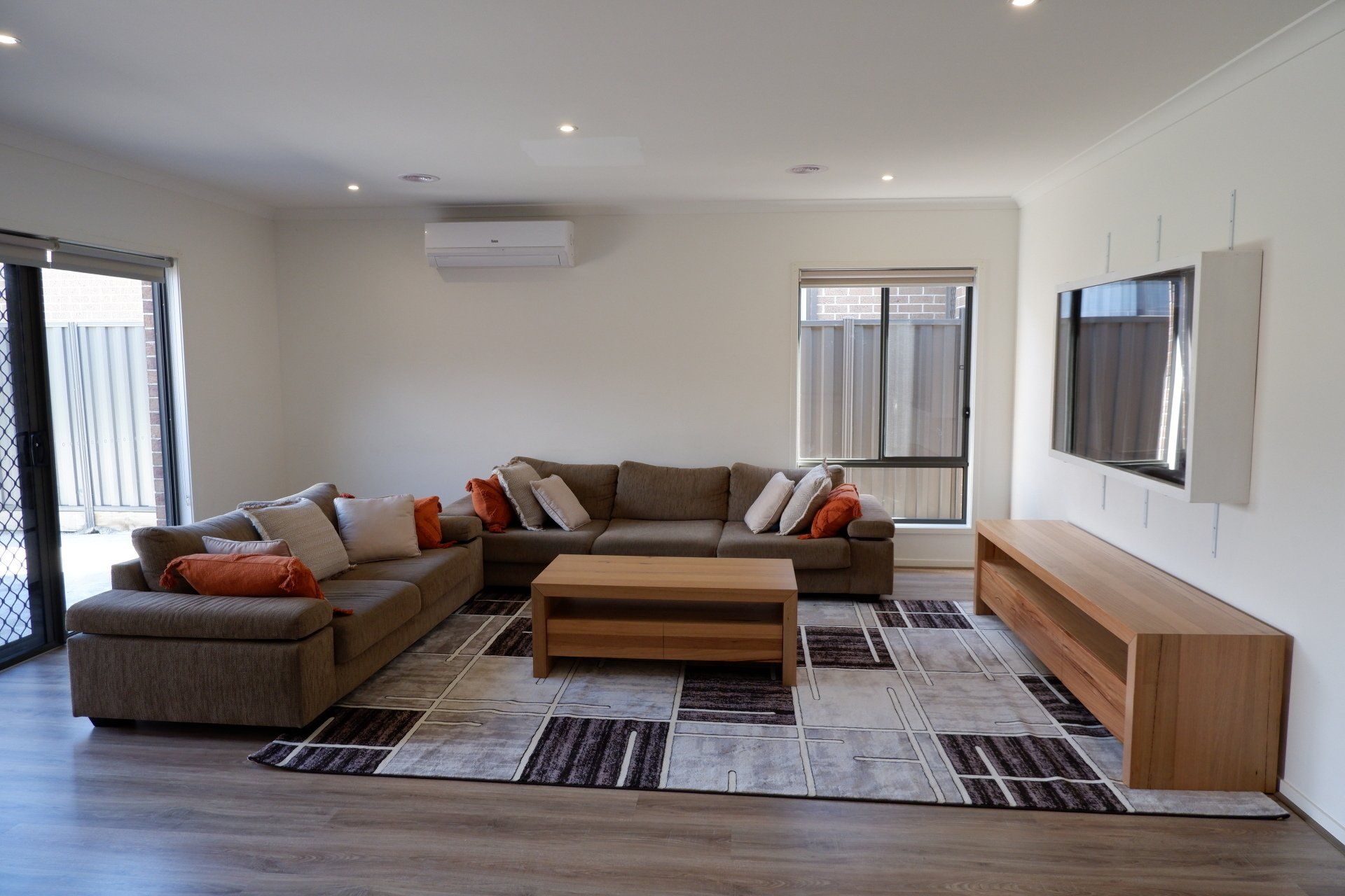 A living room with a large sectional couch and a flat screen tv