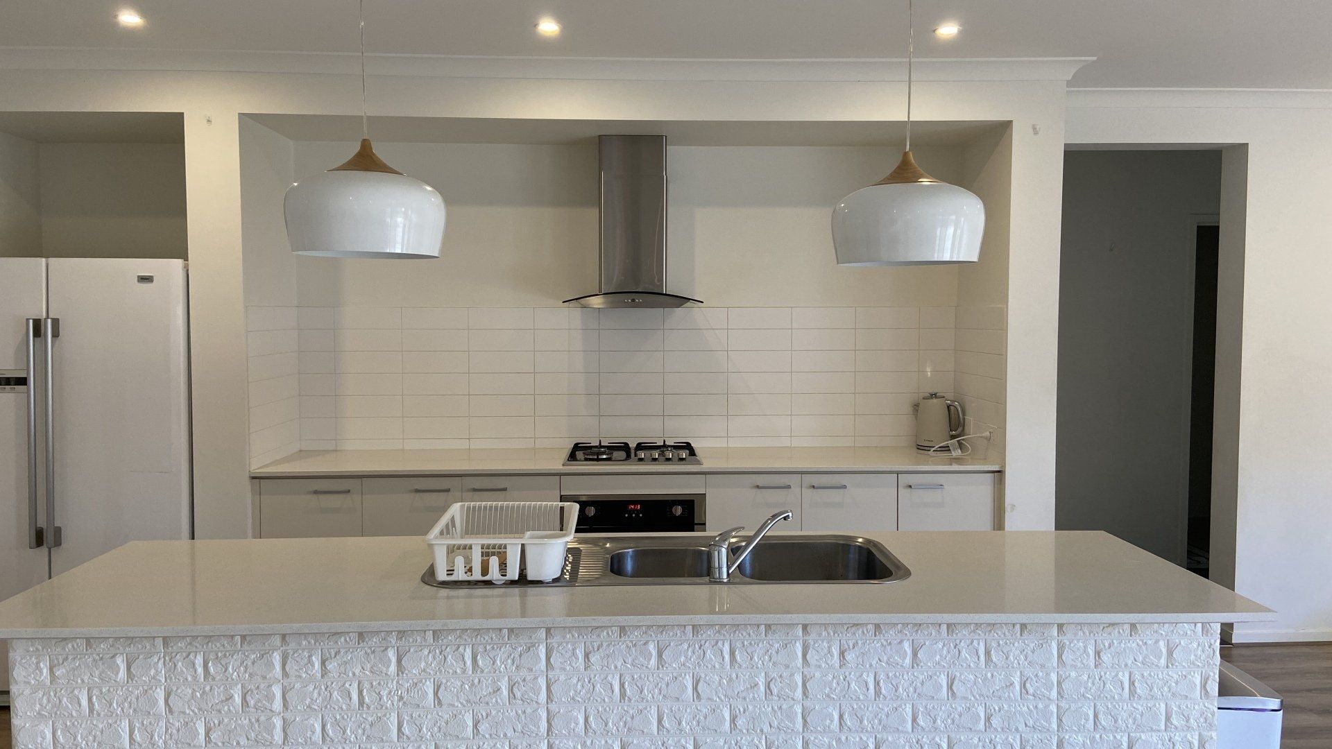 A kitchen with white cabinets , a sink and a stove.