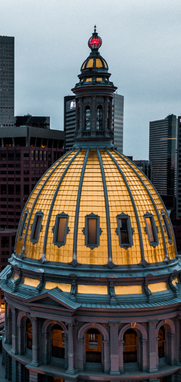 Modern living room with neutral colors, fireplace, large windows, and open staircase.