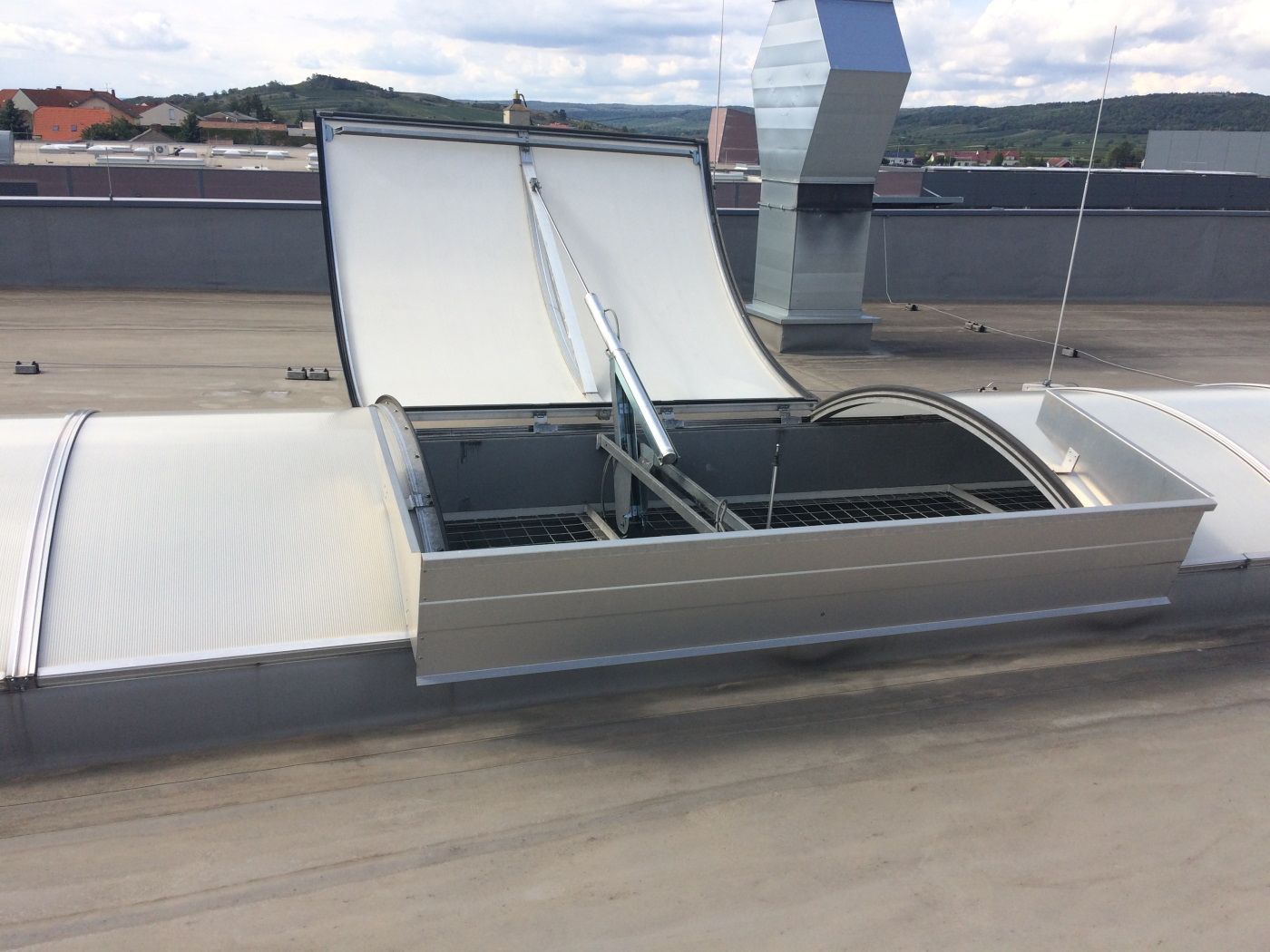 Offenes Dachlüftungssystem mit gewölbten, weißen Abdeckungen.