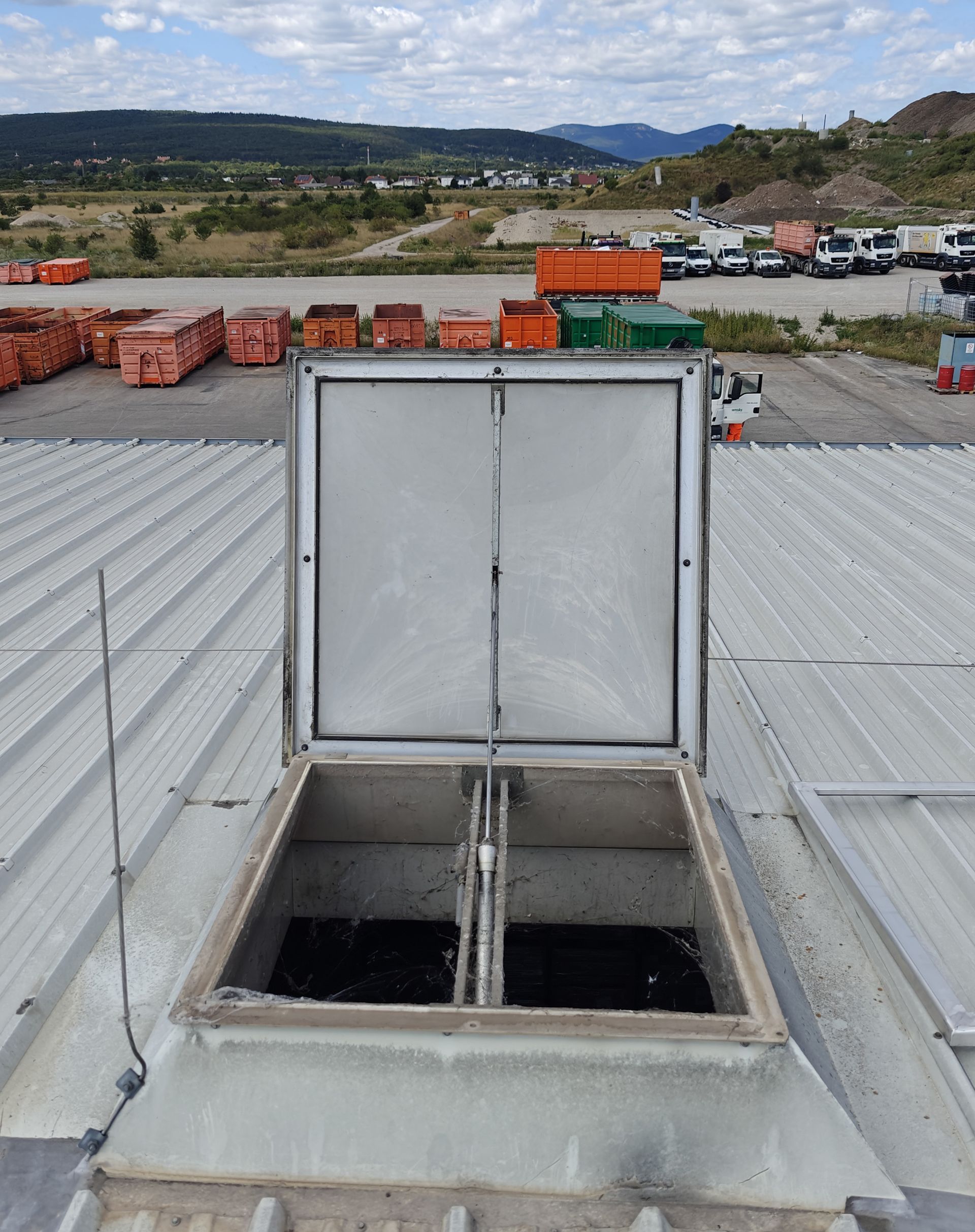 Lichtkuppel auf dem Dach eines Geschäftsgebäudes gibt den Blick auf die Innenräume frei. Metalldach im Hintergrund.